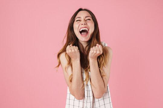 Image of excited beautiful woman screaming and making winner gesture