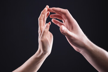 A close-up of two hands male and female gently touch each other. The concept of tremulous rejection between the sexes