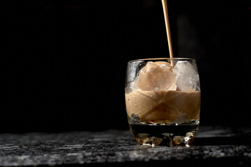 iced coffee in glass bottom with black background