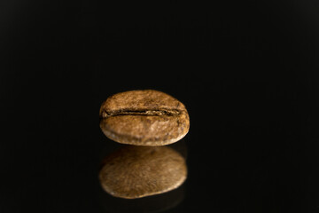 Fototapeta premium Gold coffee bean on black background.