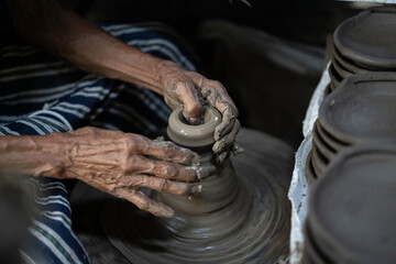 male potter is making a vase from clay, selective focus.