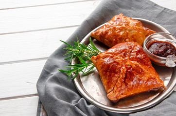 Fresh delicious puff pastry on white wooden table, top view.