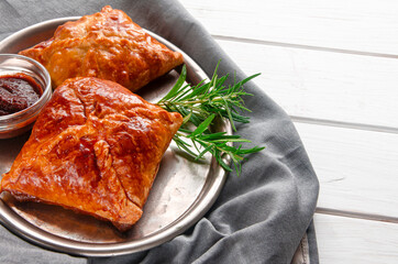 Fresh delicious puff pastry on white wooden table, top view.