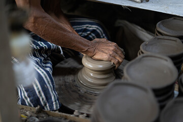 male potter is making a vase from clay, selective focus.