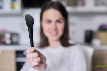 Makeup brush in the hand of a young woman, beauty, fashion