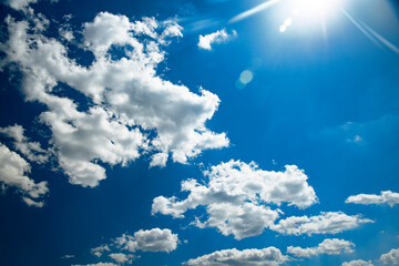 Sun rays on a blue sky with white clouds. Use for the background.
