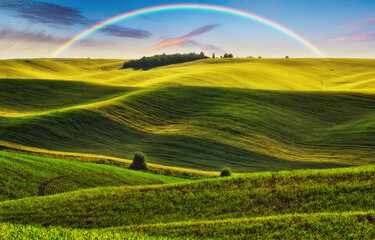 Scenic view of rainbow over green field