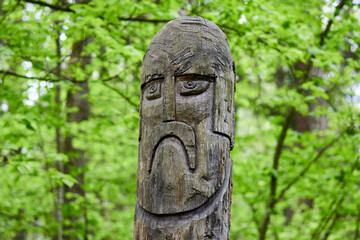 The image of the Slavic deity Veles carved from a tree trunk on a neo-Pagan temple in the forest. Kaluzhskiy region, Russia. Veles - the god of cattle breeding, wealth and wisdom