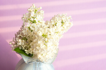 Fresh branch of lilac with a small vase. Summer bouquet.