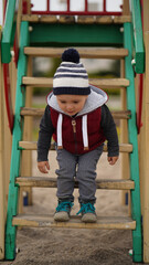 Little child descending on a ladder in a children's town
