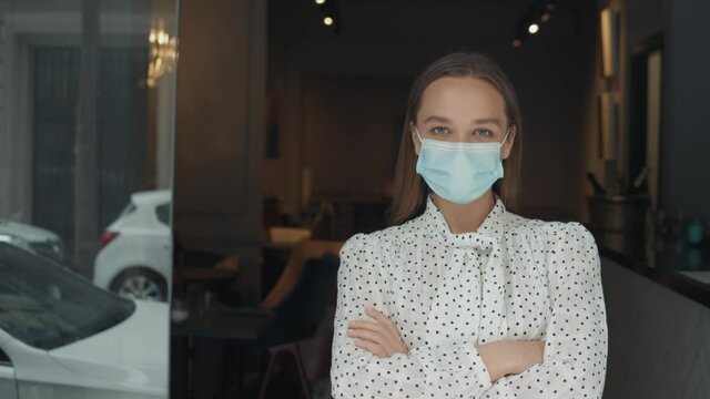 Coffee Shop restaurant Woman Owner Working With Face Mask, Open After Lockdown coronavirus Quarantine is over. Girl business owner waiter waiting customers, first days after covid