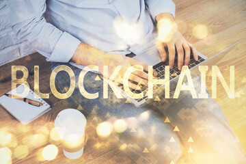 Crypto currency theme hologram with businessman working on computer on background. Concept of...