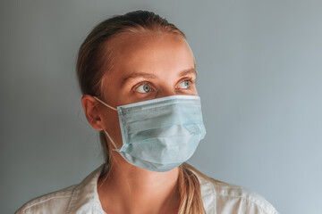 A woman in a medical mask close up