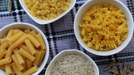 various in color and shape pasta in white bowls for a gluten-free diet and a healthy diet top view