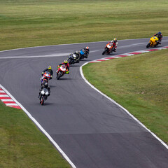Multiple racing bikes cornering on a track
