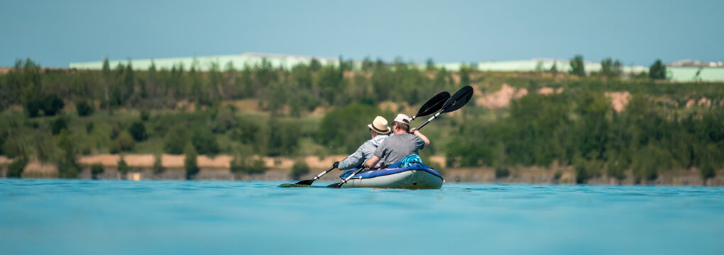 Two People Kayaking On A Lake