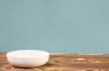 White deep plate on a wooden table