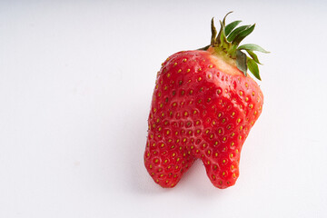 Trendy ugly strawberries on a light background
