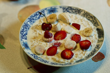 healthy breakfast - porridge with fruit strawberry, banana and cherry