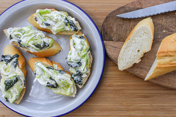  Basque pintxos canape style served in a sharing plate. Leek, seaweed and mayonnaise salad over a piece of bread. Vegan pintxo.