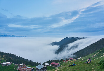 Traditional wooden houses and sea of clouds with snowy mountain. Landscape photo was taken at Pokut Plateau, Rize, northeastern Karadeniz (Black Sea) region of Turkey.