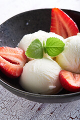 Vanilla ice cream with strawberries and almonds served in a plate