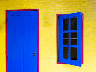 Blue Wooden Window and Door on The Red Frame in The Yellow Wall