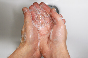 Man washing his hands with soap, wash hands concept soap foam closeup, virus prevention