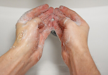 Man washing his hands with soap, wash hands concept soap foam closeup, virus prevention