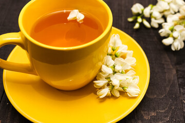 Acacia tea brewed in a cup stands on a wooden table