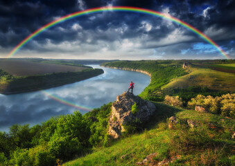 Obraz premium Woman Looking At Rainbow. rainbow over river canyon 