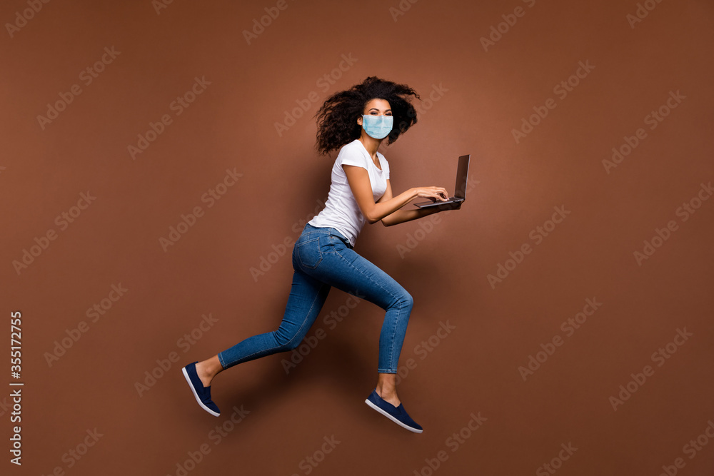 Wall mural Full length body size profile side view of her she attractive healthy wavy-haired girl wearing gauze safety mask jumping using laptop running stop cov ncov-2 isolated dark brown color background