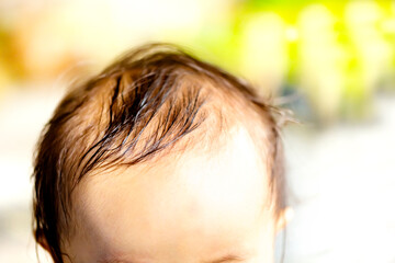 赤ちゃんの頭　前髪、または前頭部、そして汗でぬれた髪