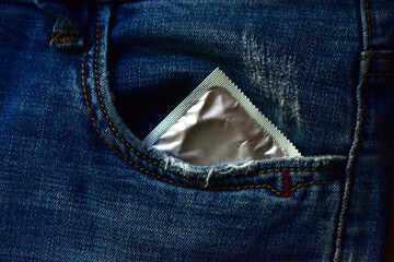 Shiny new condom in the denim pocket of your pants