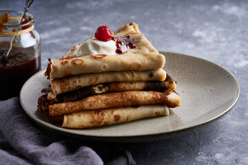 Traditional homemade pancakes with cranberries and sour cream served on gray stone table Close up.