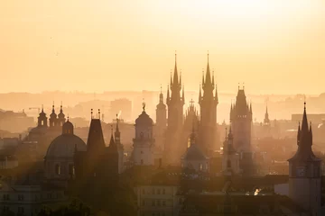 Fototapeten Prag View of foggy Prague with Charles Bridge from Petrin hill view point in the early morning with sun rays coming through the fog. Silhouettes of temples, towers and buildings. Prague, Czech Republic.  © Denis Poltoradnev