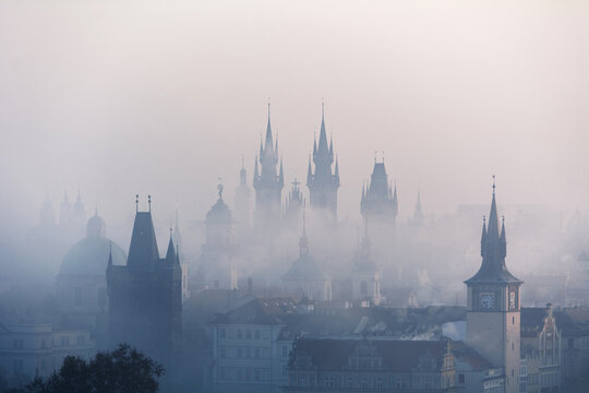 View of the centre of Prague and Charles bridge in the fog in the early morning with towers and silhouettes. Prague, Czech Republic
