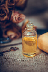 Neroli essential oil in a glass bottle with dried flowers on old textured wooden background. Selective focus.