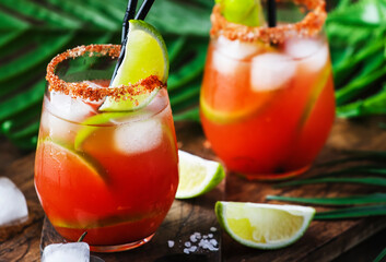 Michelada - Mexican inspired bloody mary alcoholic cocktail with beer, lime juice, tomato juice,...