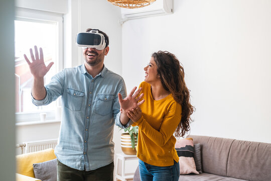 Happy couple enjoying using in virtual reality headset stock photo