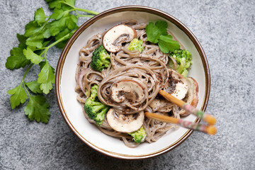 Soba noodles with mushrooms and broccoli and creamy sauce. Stir fried wok dishes Asian cuisine