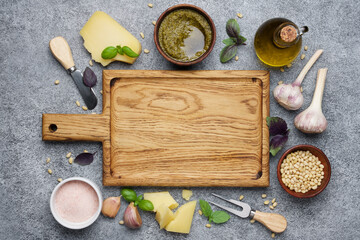Italian pesto sauce surrounded by traditional ingredients. Seasoning and kitchen tools for home cooking. Flat lay