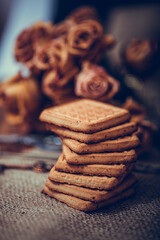 Stacked chip cookies on brown napkin. Symbolic image. Stack of biscuits concept for a tasty snack. Sweet dessert. Rustic wooden background. Selective focus. Close up.