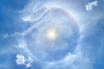 Beautiful sun halo with cloud in the blue sky backgound. Sun with Full circle rainbow