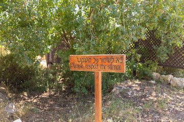 A wooden  sign with the inscription in Hebrew and English - Please, respect the silence - before entering the female monastery of Lavra Netofa not far from the village of Hararit in northern Israel