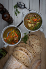 Italian vegan minestrone in white ceramic bowls served with home made ciabatta