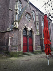 red church doors and a closed red parasol