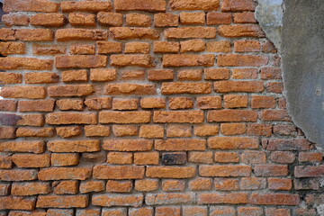 Structure of decaying vintage clay bricks wall and cement, weathered textured pattern background with copy space.