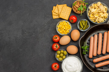 Sausages in pan. Bacon cheese, vegetables, cookies cereal yogurt: ingredients for  continental breakfast