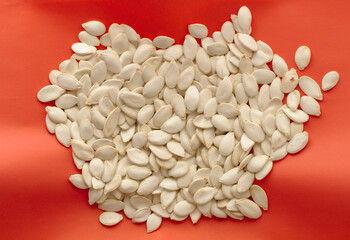 Pumpkin seeds on a red napkin. View from above. Close-up.
